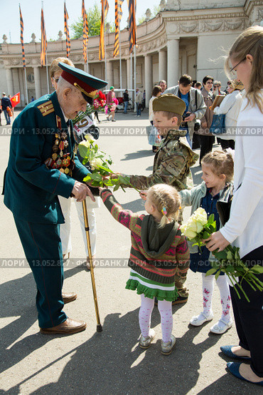 Девочка дарит цветы ветерану. 9 мая 2015 года. Редакционное фото, фотограф Михаил Ворожцов / Фотобанк Лори