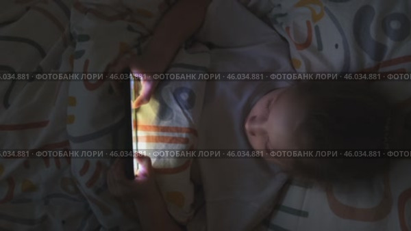 Девочка ночью играет в онлайн-игру на своем смартфоне. Зависимость детей от смартфонов. Зависимость от гаджетов. Стоковое видео, видеограф Терехова Марина / Фотобанк Лори