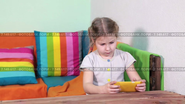 Девочка увлечена игрой на смартфоне. Стоковое видео, видеограф Кекяляйнен Андрей / Фотобанк Лори