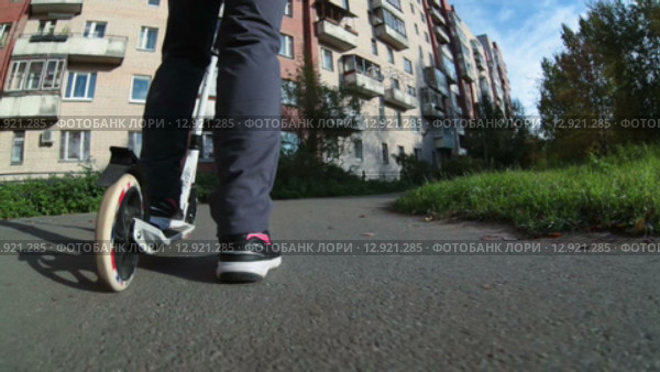 Девушка едет по асфальтовой дорожке на самокате, вид сзади и снизу. Стоковое видео, видеограф Кекяляйнен Андрей / Фотобанк Лори