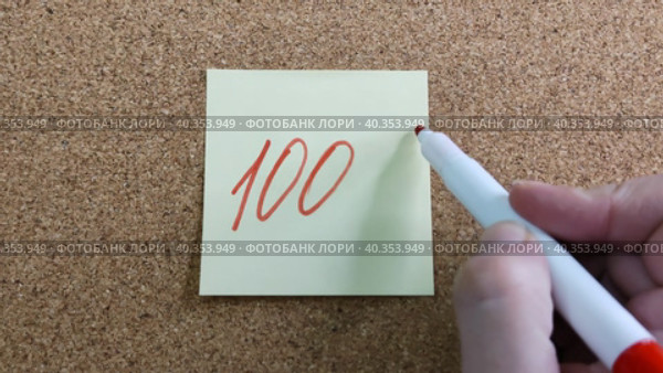 Девушка пишет надпись 100% красным маркером на желтом бумажном стикере, приклеенном к пробковой доске. Женская рука с цветным фломастером. Рукописный текст красивым почерком. Процент скидки, убытка или прибыли. Girl writes the inscription 100% with red marker on yellow paper sticker glued to cork board. Woman hand with colored felt-tip pen. Handwritten text in beautiful handwriting. Percentage of discount, loss or profit. Стоковое видео, видеограф Ирина / Фотобанк Лори