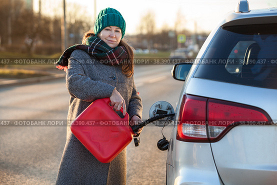 Девушка водитель собирается заправить автомобиль из пластиковой канистры на трассе. Стоковое фото, фотограф Кекяляйнен Андрей / Фотобанк Лори