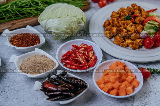 Diced carrots, dried chilies, roasted rice, chili, and cabbage are placed on a cement floor. Стоковое фото, агентство Ingram Publishing / Фотобанк Лори