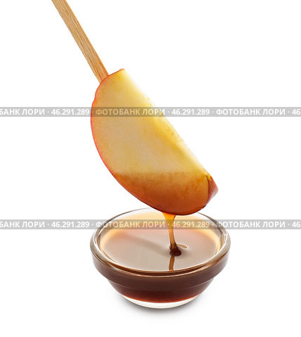 Dipping of apple wedge into glass bowl with sauce on white background. Стоковое фото, фотограф Pixel_shot / Фотобанк Лори