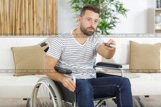 disabled man watching sports on tv. Стоковое фото, агентство Ingram Publishing / Фотобанк Лори