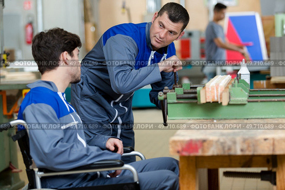 disabled worker in wheelchair in factory. Стоковое фото, агентство Ingram Publishing / Фотобанк Лори
