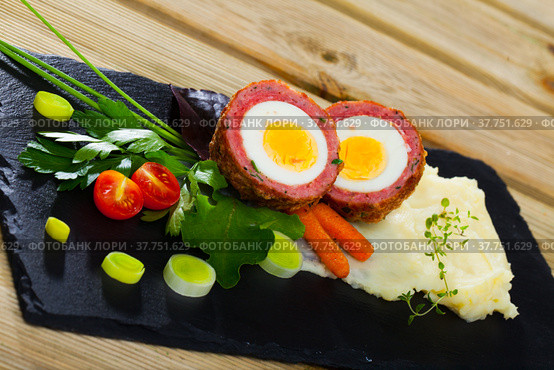 Dish scotch egg with tomatoes, mashed potatoes and greens, traditional Scottish cuisine. Стоковое фото, фотограф Яков Филимонов / Фотобанк Лори