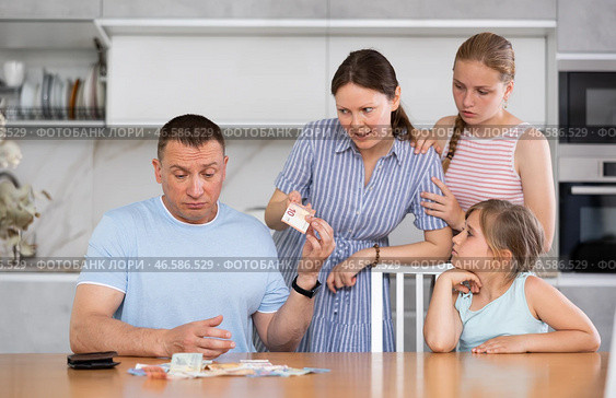 Dissatisfied woman demanding money from perplexed husband at home. Стоковое фото, фотограф Яков Филимонов / Фотобанк Лори