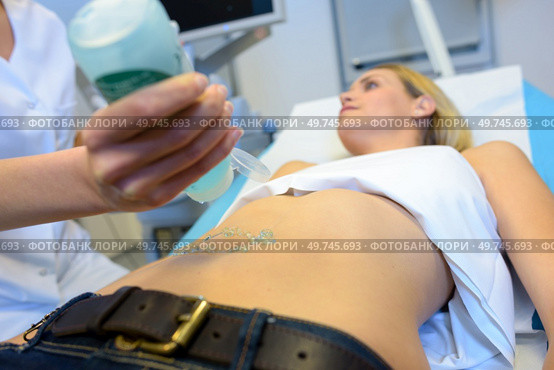 doctor doing an ultrasound of a patient abdomen. Стоковое фото, агентство Ingram Publishing / Фотобанк Лори