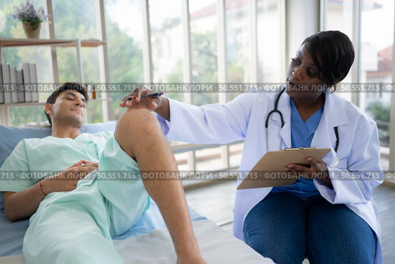 Doctor examining knee joint function of patient in hospital, Medical health care. Стоковое фото, агентство Ingram Publishing / Фотобанк Лори