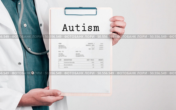 Doctor holding Paper Pad with Text Autism. Стоковое фото, агентство Ingram Publishing / Фотобанк Лори