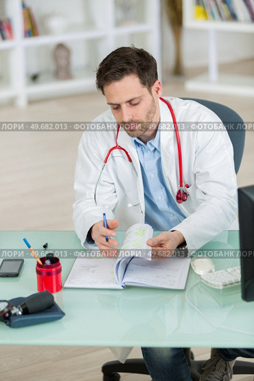 doctor talking checking his agenda in the office. Стоковое фото, агентство Ingram Publishing / Фотобанк Лори