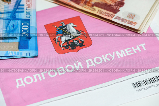Долговой документ за коммунальные услуги и российские рубли. Оплата коммуналки (2018 год). Редакционное фото, фотограф Игорь Низов / Фотобанк Лори