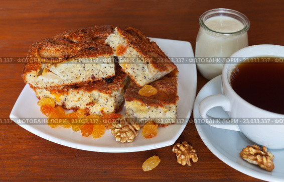 Домашний манный пирог с изюмом, яблоком и маком на столе с чашкой чая и баночкой кефира на полдник. Стоковое фото, фотограф Виктория Катьянова / Фотобанк Лори