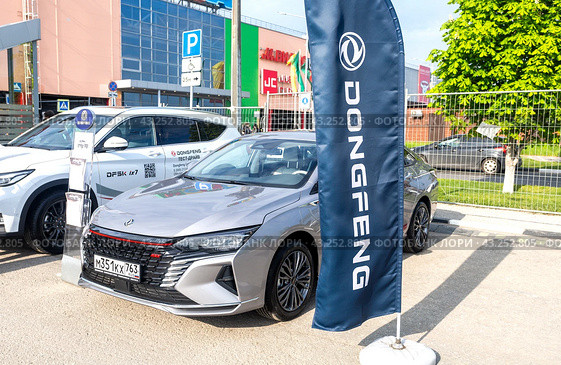 Dongfeng vehicles at the city street. Dongfeng Motor is a Chinese automaker (2024 год). Редакционное фото, фотограф FotograFF / Фотобанк Лори
