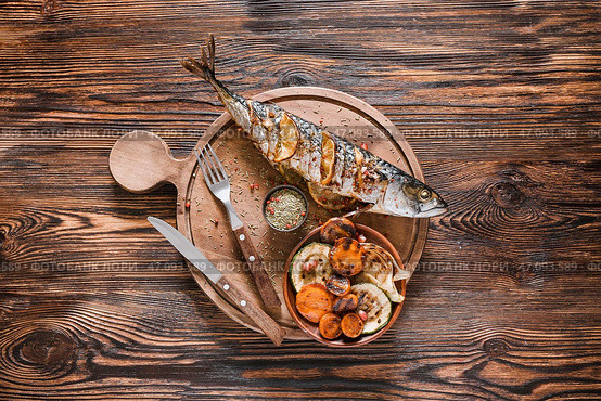 Доска с готовой скумбрии рыбой и овощами на деревянном фоне. Стоковое фото, фотограф Pixel_shot / Фотобанк Лори
