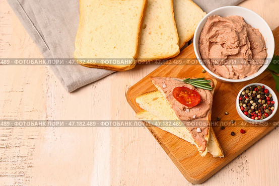 Доска с миской вкусного паштета, бутербродами и перцем на светлом деревянном фоне. Стоковое фото, фотограф Pixel_shot / Фотобанк Лори