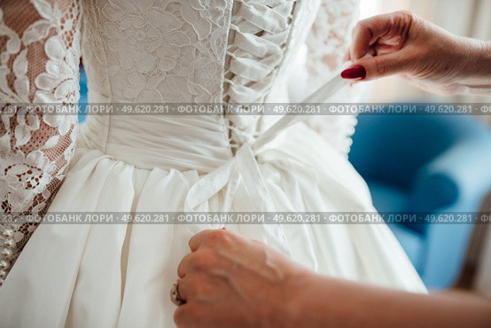dress up the bride in a wedding dress with corset and lacing. Стоковое фото, агентство Ingram Publishing / Фотобанк Лори