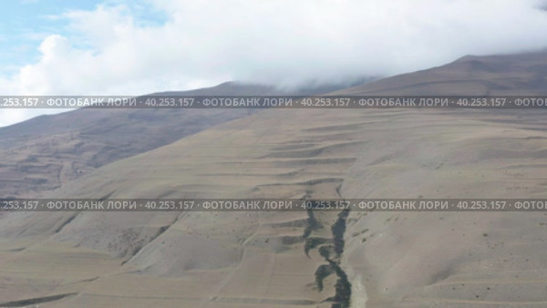 Drone flying above gorge toward terraced mountain slope. Стоковое видео, видеограф Кирилл Трифонов / Фотобанк Лори