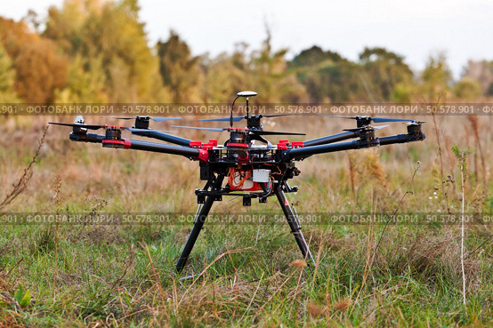Drone on a background of a beautiful sunset. UAV in flight. Quadrocopters on radio.. Oktokopter, copter, drone. Стоковое фото, агентство Ingram Publishing / Фотобанк Лори