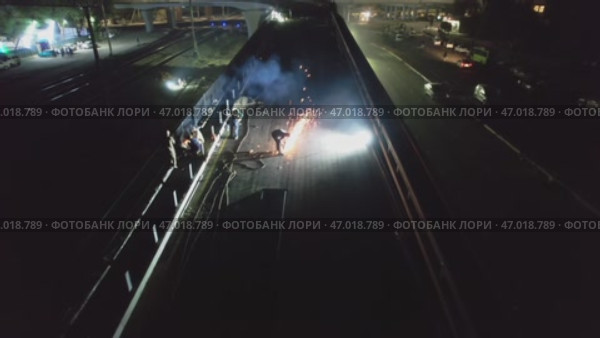 Drone over a road under repair with welding work at night. Стоковое видео, видеограф Aleksey Kidisyuk / Фотобанк Лори