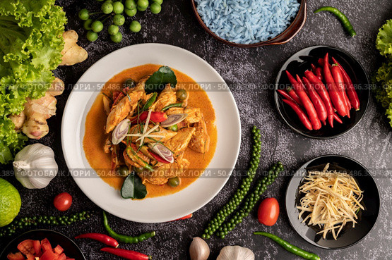 Dry green curry with chicken in white plates on black cement. Стоковое фото, агентство Ingram Publishing / Фотобанк Лори