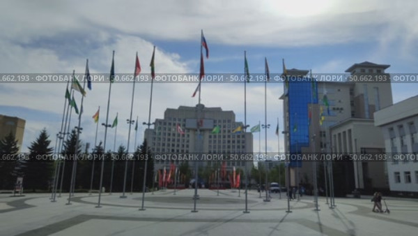 Drygin Square on warm spring day. Flags of Russia and municipalities of region. View of Vologda Region Governor Office. Shooting against sun. Vologda, Russia, May 23, 2025. Редакционное видео, видеограф Ирина / Фотобанк Лори