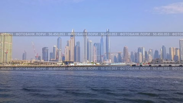Dubai, UAE - June 26, 2025: Dubai skyline with Marina skyscrapers seen from Palm Jumeirah waterfront. Редакционное видео, видеограф Оксана Чаюн / Фотобанк Лори