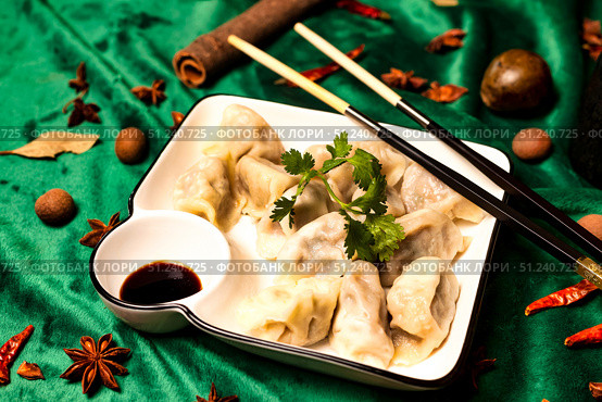 Dumplings on Plate Surrounded by Spices Evoke Tradition and Warmth. Стоковое фото, фотограф Aleksandr Golubev / Фотобанк Лори