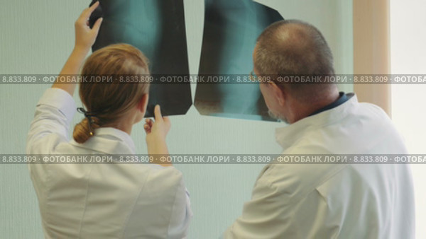 Два доктора обсуждают рентгеновские снимки. Стоковое видео, видеограф Данил Руденко / Фотобанк Лори