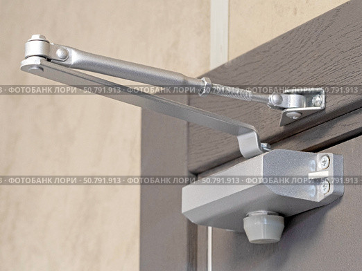 Дверной металлический доводчик, установленный на двери. Automatic hydraulic device, leaver hinge door closer holder on a white background. Стоковое фото, фотограф Татьяна Д / Фотобанк Лори