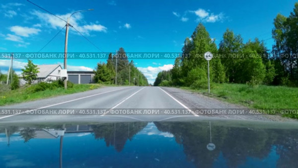 Движение на машине по дороге в поселке Эссойла в Карелии в солнечный день. Вид на широкий угол от первого лица с капота машины. (2023 год). Редакционное видео, видеограф Sergei Gorin / Фотобанк Лори
