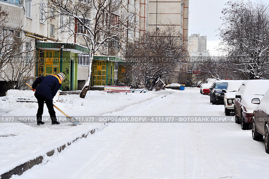 Дворник чистит тротуар от снега во дворе многоэтажного дома (2011 год). Редакционное фото, фотограф Анна Мартынова / Фотобанк Лори