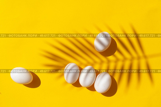 Easter scene with white eggs over illuminating yellow background, palm sunday concept. Easter scene with white eggs. Стоковое фото, агентство Ingram Publishing / Фотобанк Лори