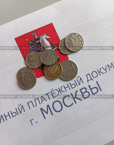 Единый платежный документ квитанция ЕПД и стопки столбики монет мелочи деньги для оплаты жилищно-коммунальные услуги, долговой документ за неуплату ЖКУ. Стоковое фото, фотограф burnet / Фотобанк Лори