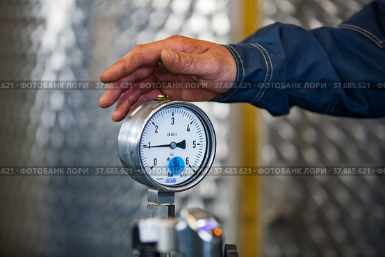 Ekibastuz, Kazakhstan - May 28, 2012. Explosive material production plant for coal quarry mining. Manometer gauge and worker's hand. Close up. Стоковое фото, фотограф Alexey Rezvykh / Фотобанк Лори