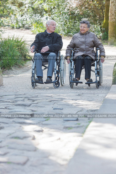 Elderly couple promenading in wheelchairs. Стоковое фото, агентство Ingram Publishing / Фотобанк Лори