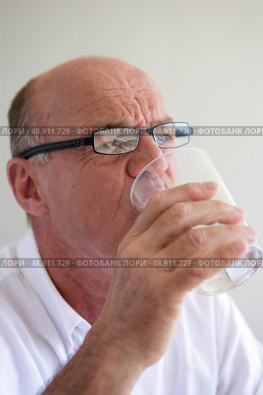Elderly man drinking a glass of water. Стоковое фото, агентство Ingram Publishing / Фотобанк Лори