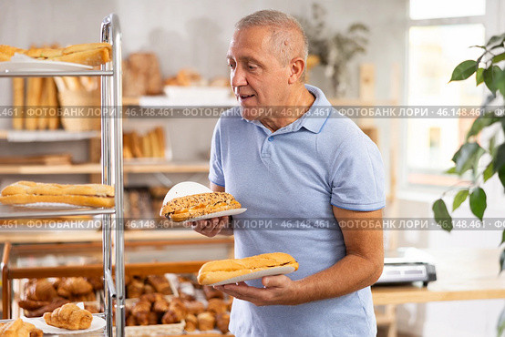 Elderly man with bocadillo sandwich in bakery. Стоковое фото, фотограф Яков Филимонов / Фотобанк Лори