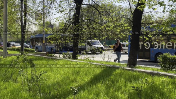 Electric buses move in the city morning traffic flow against the background of young spring foliage on Stromynka Street. Moscow 14.05.023 (2023 год). Редакционное видео, видеограф Ярославский Максим / Фотобанк Лори