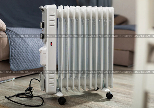 Electric oil heater on floor in room. Стоковое фото, фотограф Яков Филимонов / Фотобанк Лори