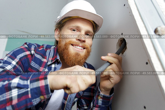 electrical renovation work wiring in pipe wall. Стоковое фото, агентство Ingram Publishing / Фотобанк Лори