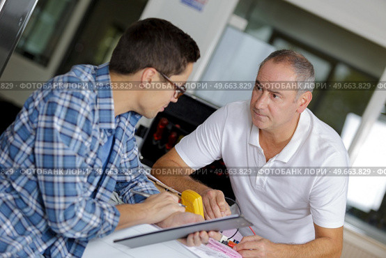 electrician apprentice using multimeter teacher monitoring. Стоковое фото, агентство Ingram Publishing / Фотобанк Лори