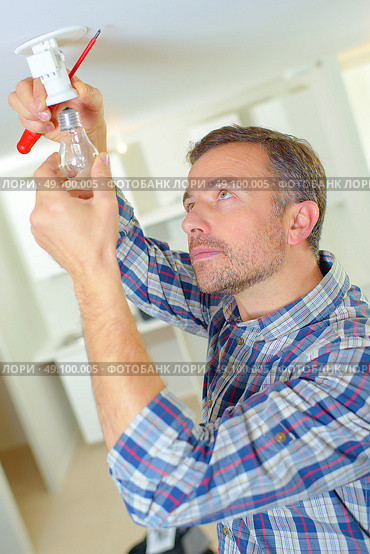 Electrician changing a light bulb. Стоковое фото, агентство Ingram Publishing / Фотобанк Лори
