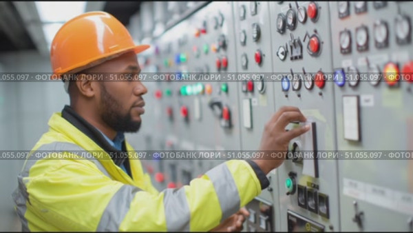 Electrician operates control panel in industrial facility during daytime work shift. Стоковое AI-видео, аниматор Сергей Толмачёв / Фотобанк Лори