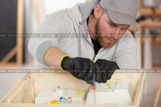 electrician preparing fuses in a circuit-breaker box. Стоковое фото, агентство Ingram Publishing / Фотобанк Лори