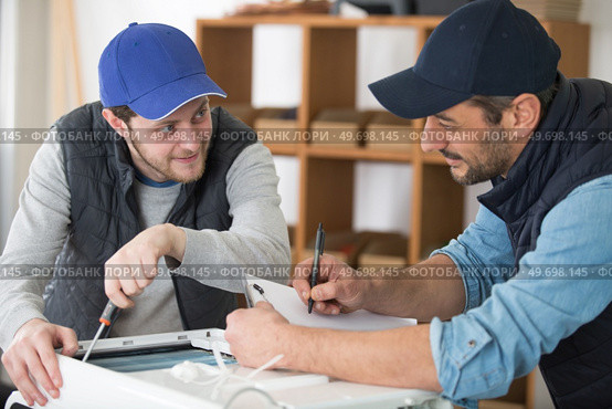 electrician with apprentice working in new home. Стоковое фото, агентство Ingram Publishing / Фотобанк Лори