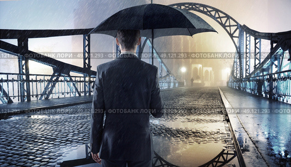 Elegant man holding a black umbrella. Стоковое фото, агентство Ingram Publishing / Фотобанк Лори