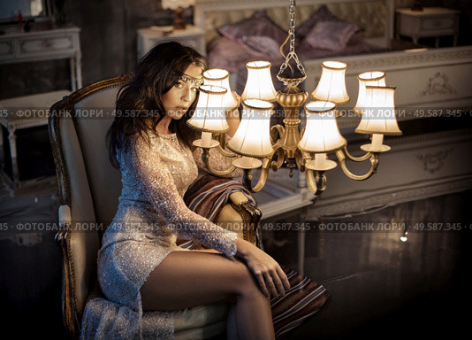 Elegant, young woman holding an antique chandelier. Стоковое фото, агентство Ingram Publishing / Фотобанк Лори