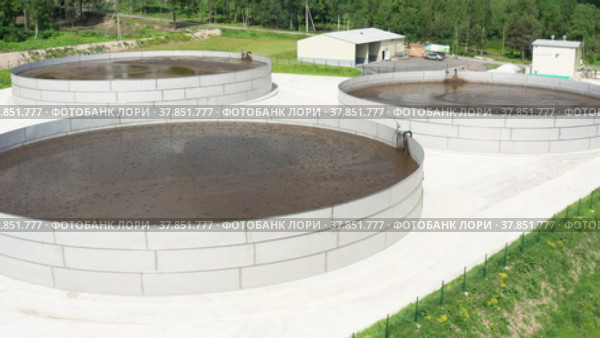 Емкости с жидким навозом на территории животноводческой фермы. Вид с воздуха. Tanks with liquid manure on the territory of a livestock farm. Aerial view. (2022 год). Редакционное видео, видеограф Евгений Романов / Фотобанк Лори